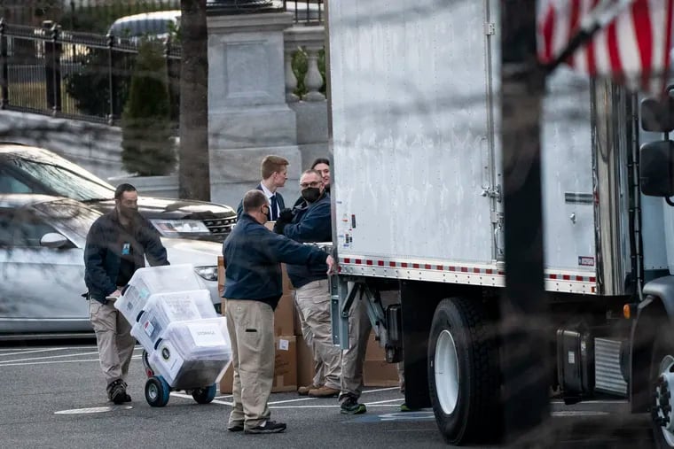Workers load boxes of newspapers and other items into a truck outside the Eisenhower Executive Office Building in the White House complex on Jan. 14, 2021.