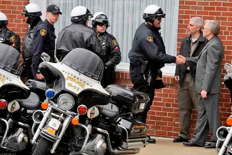 Pittsburgh police officers gather outside the Winter Funeral Home during a viewing for fallen Police Officer Paul Sciullo II, killed Saturday along with two colleagues.