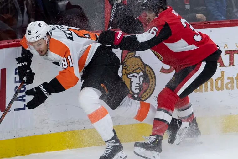 The Senators' Colin White checks the Flyers' Carsen Twarynski along the boards during the second period Friday night in Ottawa. The Flyers lost, 2-1.