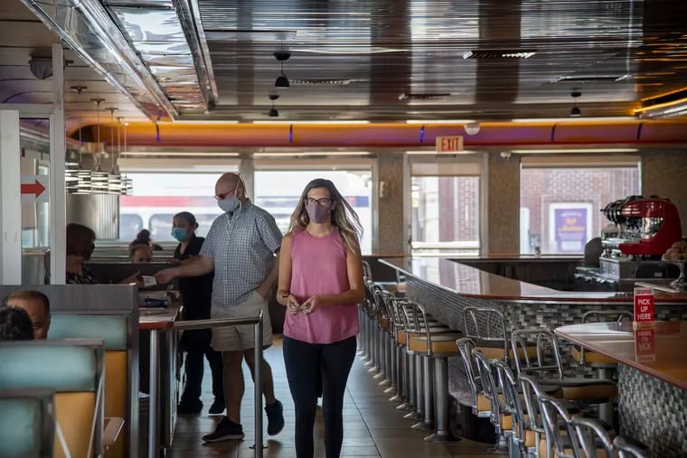 Mikaela Roper Penardo, walks to her seat inside the Melrose Diner in September. The city is again shutting down indoor dining.