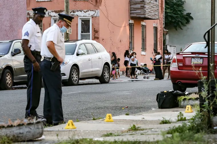 Kids watch from the corner as 22nd District Police investigating at the scene at Park avenue and York where two men were shot, Tuesday, July 7, 2020