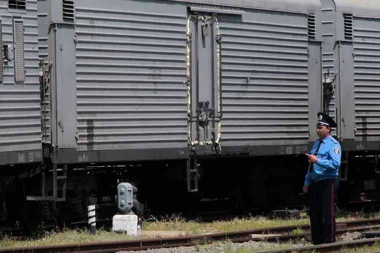 A police officer stands near a refrigerated train loaded with bodies of the passengers of Malaysian Airlines Flight 17 at the railway station in Kharkiv, which is controlled by Ukrainian forces.