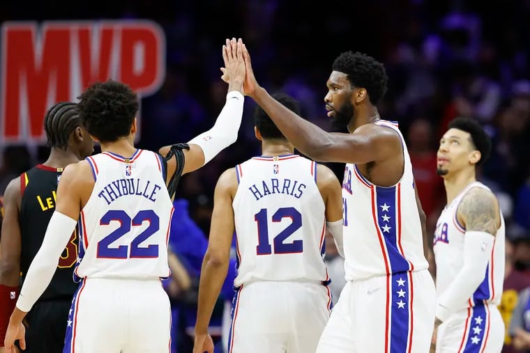 Sixers center Joel Embiid high-fives teammate guard Matisse Thybulle against the Cleveland Cavaliers on Saturday, February 12, 2022 in Philadelphia.