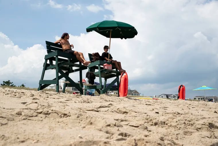 Harvey Cedars Beach Patrol lifeguards Matt Boblenz, 22, and Alex Pendrous,16, in their chairs on the beach in Harvey Cedars on Long Beach Island, N.J. on Sunday, July 26, 2020. More than 20 lifeguards on Long Beach Island tested positive for the coronavirus.