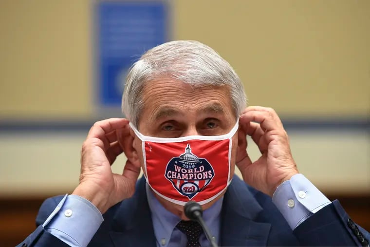 Dr. Anthony Fauci, director of the National Institute for Allergy and Infectious Diseases, adjusts his Washington Nationals face mask during the House session Friday.