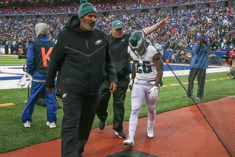 Eagles running back Miles Sanders, right, is escorted to the dressing room in the third quarter during the game against the Buffalo Bills.
