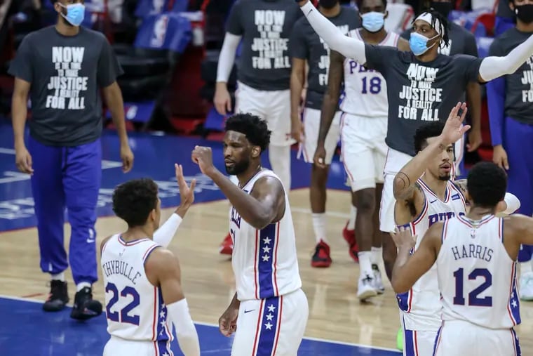 Sixers celebrate their 117-109 win over the Celtics.