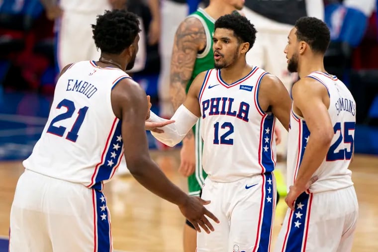 Sixers center Joel Embiid celebrates with forward Tobias Harris and guard Ben Simmons during Wednesday's win against the Celtics.