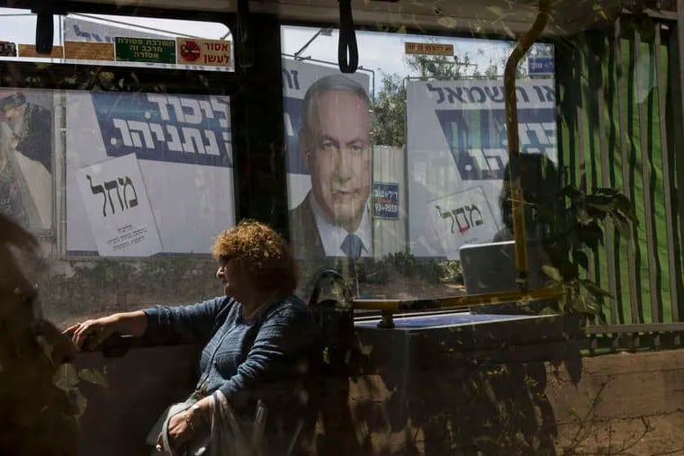 Near Tel Aviv, a Netanyahu campaign billboard dominates the landscape as a bus rolls by on the day before elections. The prime minister is in a tight race for a fourth term. Voters go to the polls on Tuesday.