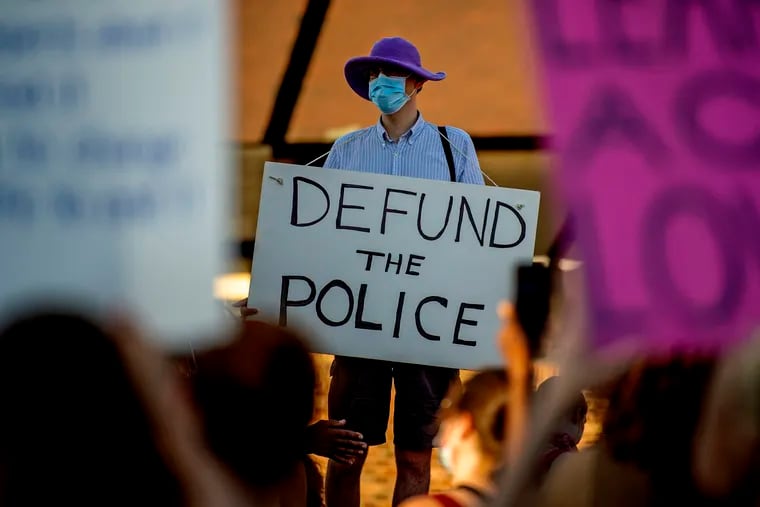 Mike Ewall of Northeast Philadelphia holds a "Defund the Police" sign at a demonstration against racism - and for justice for George Floyd - in Northeast Philadelphia on June 9, 2020.