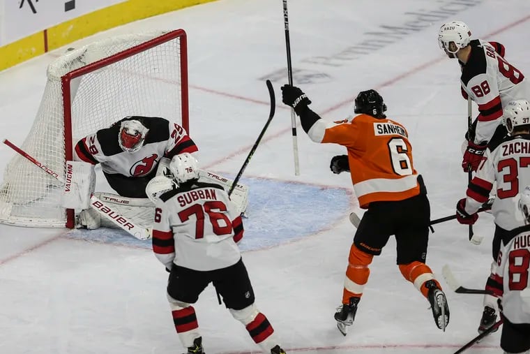 Flyers defenseman Travis Sanheim gets the puck past Devils goalie Mackenzie Blackwood to open the scoring Tuesday. The goal, Sanheim's first of the season, helped the Flyers breeze to a 6-1 victory at the Wells Fargo Center.