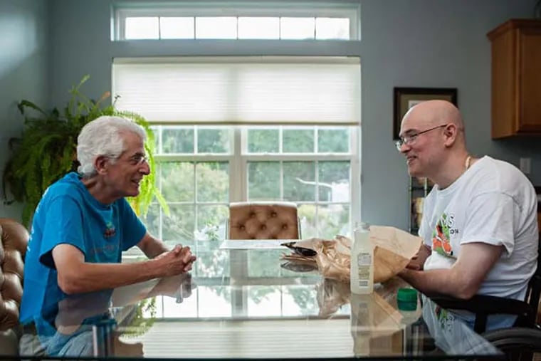 Photographer Ted Goldman (left) spent four days photographing intimage details in the daily life of Fred Schwartz, who has fought multiple sclerosis for 20 years. August 26, 2014, Burlington, New Jersey. ( MATTHEW HALL / Staff Photographer )