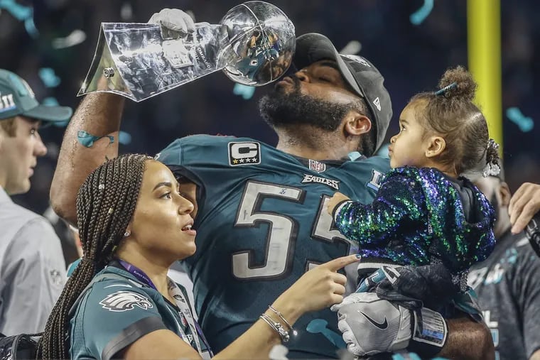 Eagles defensive hero Brandon Graham shares his trophy moment with his wife, Carlyne, and daughter, Emerson Abigail, after Super Bowl LII. MICHAEL BRYANT / Staff Photographer