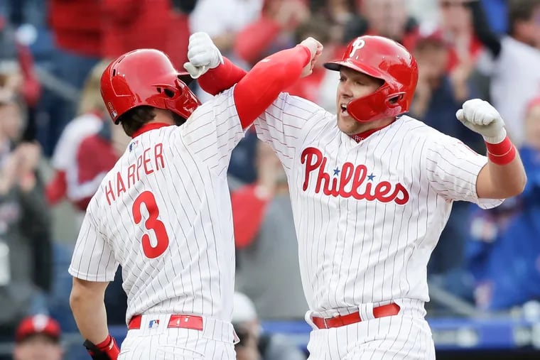 Phillies Rhys Hoskins celebrates his seventh-inning grand slam home run with teammate Bryce Harper against the Atlanta Braves on Thursday, March 28, 2019 in Philadelphia.
