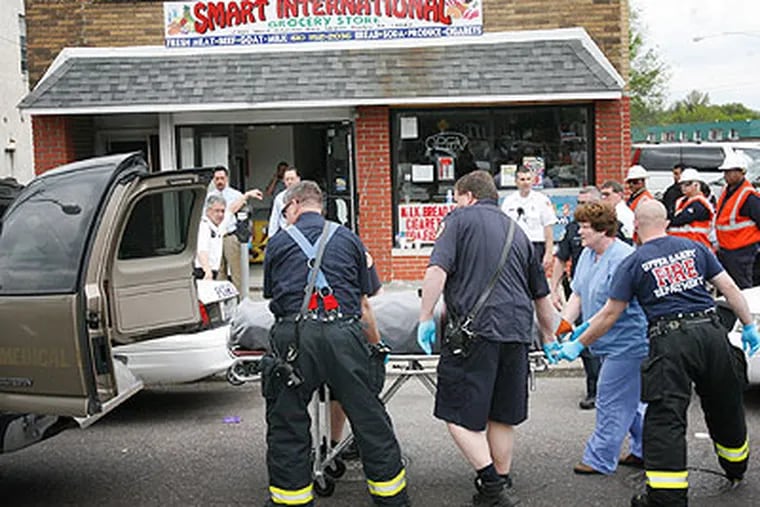 Upper Darby police load one of two bodies found in an apartment above Smart International Grocery, 7301 W. Chester Pike, Police said a generator was left running in the store and the fumes seeped up to the second floor apartment, killing the occupants. (Alejandro A. Alvarez / Staff Photographer)