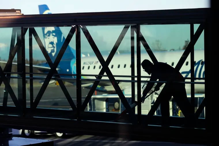 A worker cleans a jet bridge before passengers board an Alaska Airlines flight to Portland, Ore., at Paine Field in Everett, Wash., in March. U.S. employers added 263,000 jobs in April.