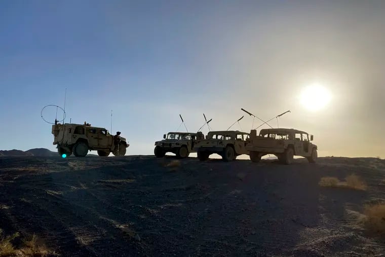 Army vehicles on the ridge, as soldiers from the 2nd Brigade, 1st Cavalry Division, prepare to attack the enemy in the town nearby, during an early morning training exercise at the National Training Center at Fort Irwin, Calif., April 12, 2022.