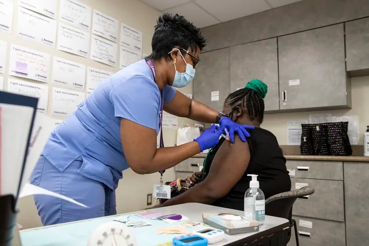 Loleatha Jackson (left) gives Falisha Tessilimi her second COVID-19 vaccination shot at the Einstein Community Vaccination Center on Tabor Road earlier this month.