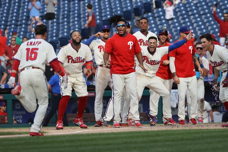 Andrew Knapp is greeted by his teammates at home plate after hitting a walkoff home run in the bottom of the 13th inning to give the Phillies the 4-3 win over the National on Sunday at a steamy Citizens Bank Park.