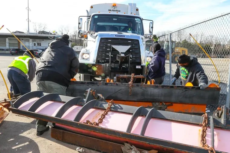 Philadelphia sanitation workers attach a snow plow to a trash truck. In a recent survey, just 32 percent of residents rated snow removal good or excellent.