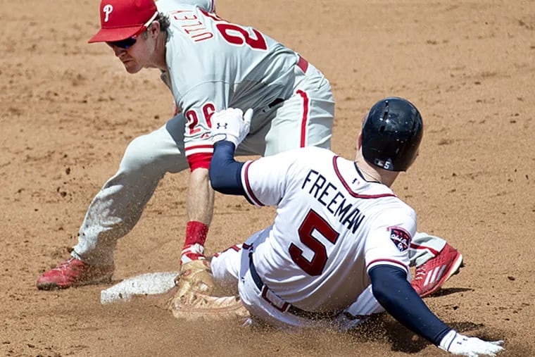 Braves first baseman Freddie Freeman is safe at second with a double as Phillies second baseman Chase Utley applies the late tag in the fifth inning on Wednesday, Sept. 3, 2014, in Atlanta. (John Bazemore/AP)