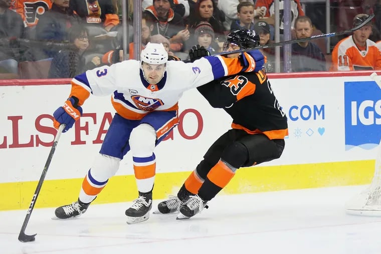 New York Islanders' Adam Pelech (3) and Flyers' Oskar Lindblom (23) fight for the puck during a game at the Wells Fargo Center in South Philadelphia on Saturday, March 23, 2019.