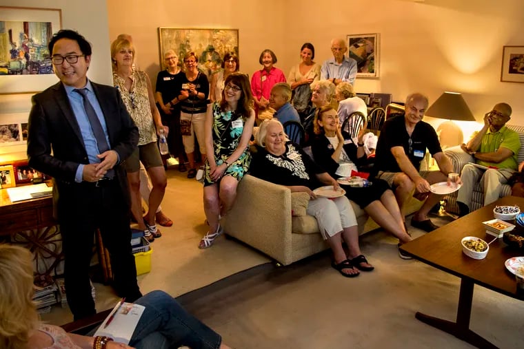 Andy Kim (left) speaks during a fundraiser at a supporter's home in Mt. Laurel August 20, 2018. A Democrat, Kim is campaigning in the competitive Second Congressional District challenging Republican incumbent U.S. Rep. Tom MacArthur. Seated on arm of sofa at center is retired physician Eileen Hill, 64, of Mount Laurel, who after President Trump's election started a chapter of "Individible"; through the South Jersey NOW-Alice Paul Chapter.