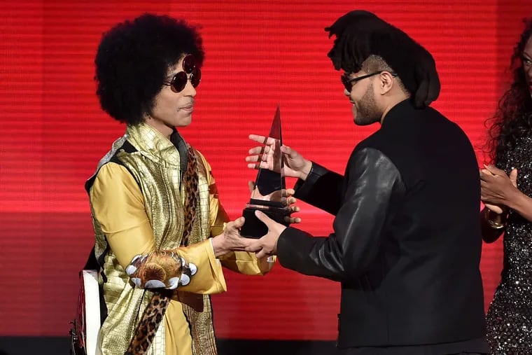 The Weeknd (right) accepts the award from Prince for favorite soul/R&B album for &quot;Beauty Behind the Madness.&quot;