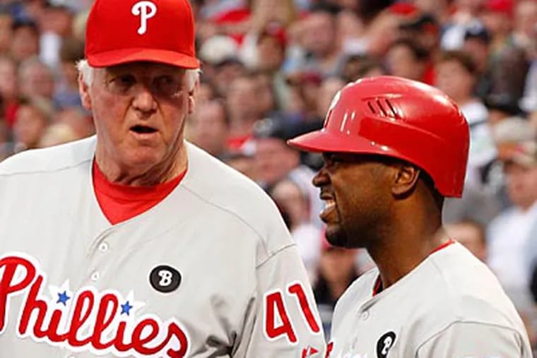 Charlie Manuel checks on Jimmy Rollins after he fouled a ball off his knee in the first inning. (Gene J. Puskar/AP)