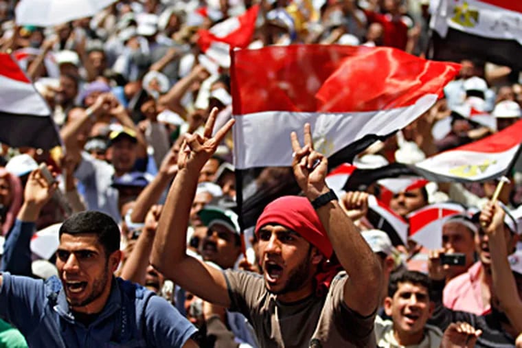 Protesters wave national flags in Cairo's Tahrir Square as they accuse Egypt's ruling generals of manipulating the approaching elections. KHALIL HAMRA / Associated Press