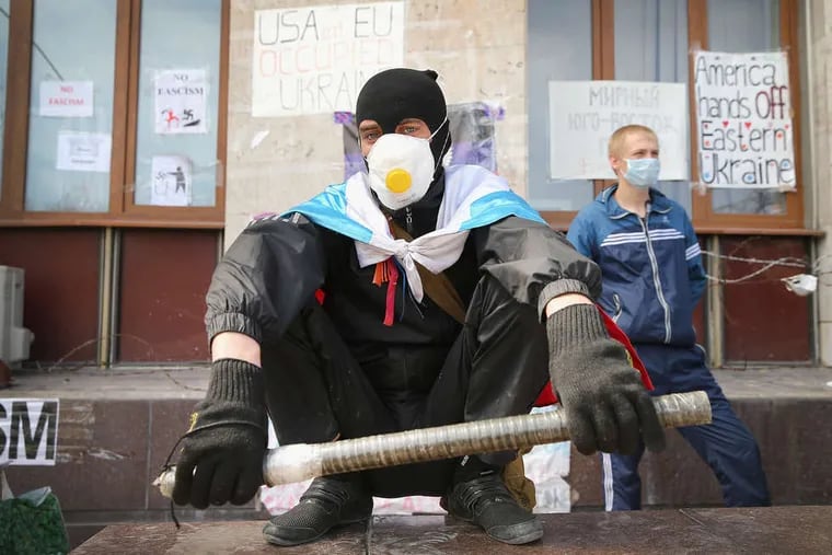 Pro-Russia activists stand guard in front of an administration building in Donetsk, Ukraine. They are refusing to disarm.