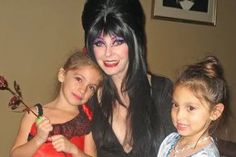 Elvira (Cassandra Peterson) at the Edgar Allan Poe House with young fans Isabel (left) and Allie Virilli.