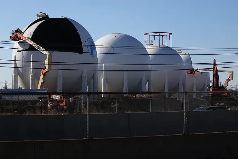 Workers disassemble butane tanks in the north yard of the former Philadelphia Energy Solutions refinery in South Philadelphia on Tuesday, Nov. 24, 2020. The PES site was purchased by Hilco Redevelopment Partners, which plans to demolish the refinery and build a set of warehouses in its place.