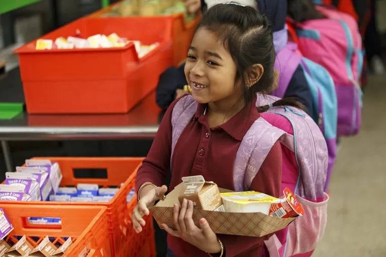 Six-year-old Jenny Song grabs breakfast in the cafeteria of Francis Scott Key Elementary School in South Philadelphia. Attendance and other markers have increased as a result of increased school breakfast participation, officials say.