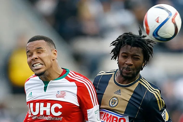 The Union's Michael Lahoud heads the soccer ball against the Revolution's Charlie Davies. (Yong Kim/Staff Photographer)