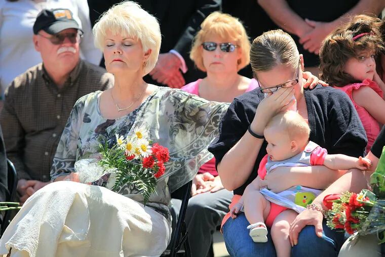 Diane Neary, Lt. Robert Neary’s widow, comforts Capt. Michael Goodwin’s daughter, Dorothy, Tuesday during a ceremony honoring the fallen firefighters outside City Hall.
JAD SlEIMAN / STAFF PHOTOGRAPHER