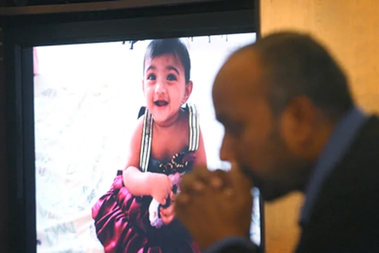 A slide of Saanvi Venna, slain last week, as Subash Karra sits nearby. (Charles Fox / Staff Photographer)