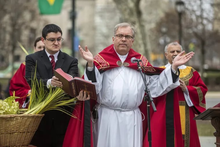 The Rev. Gerald Dennis Gill leads the congregation in prayer outside the Cathedral Basilica of SS. Peter and Paul in Philadelphia on Palm Sunday.