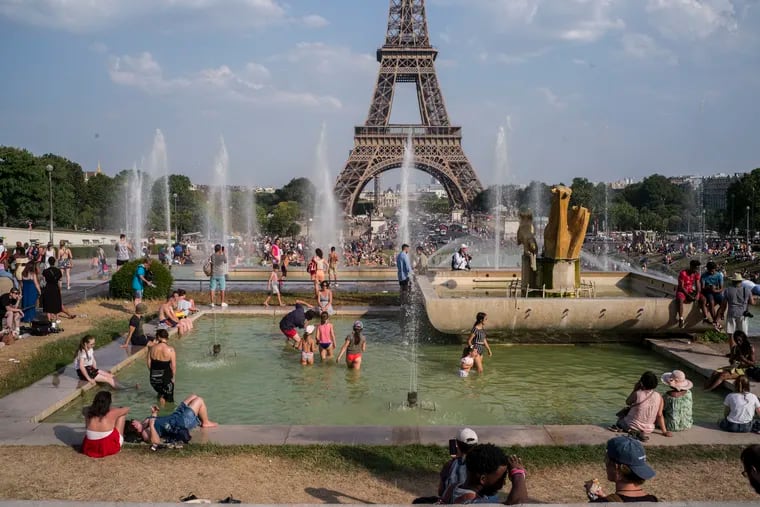 People enjoy the sun and the fountains of the Trocadero gardens in Paris, Thursday July 25, 2019, when a new all-time high temperature of 42.6 degrees Celsius (108.7 F) hit the French capital.