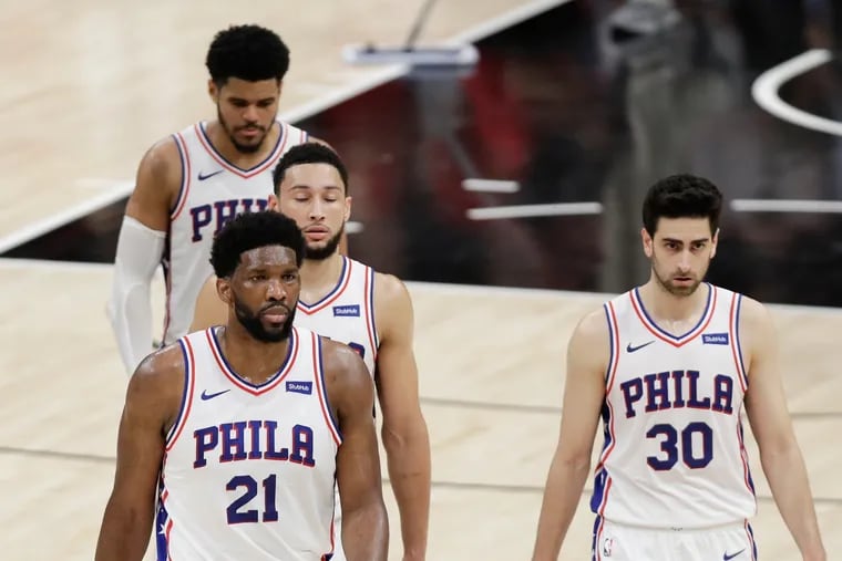 Sixers center Joel Embiid (21),  guard Furkan Korkmaz (30),  guard Ben Simmons, and forward Tobias Harris (rear)  walk back to their bench late in Game 4.
