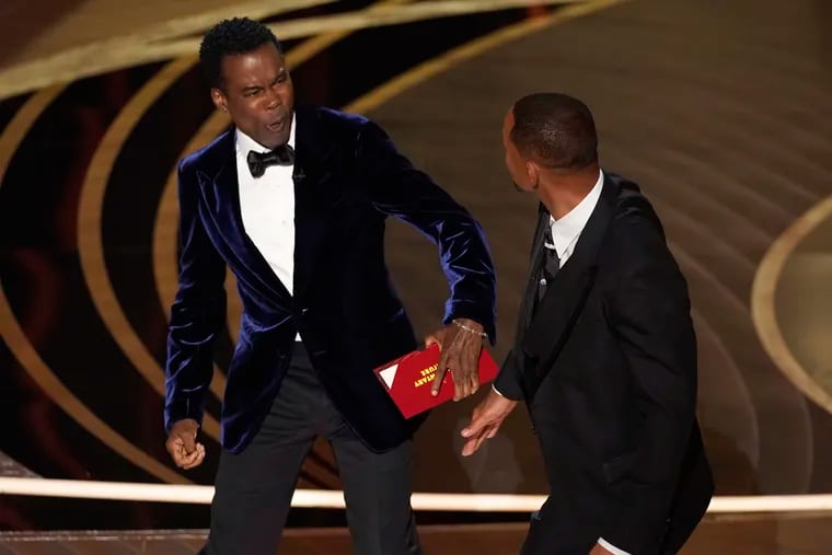 Presenter Chris Rock reacts after being hit on stage by Will Smith while presenting the award for best documentary feature at the Oscars on Sunday at the Dolby Theatre in Los Angeles.