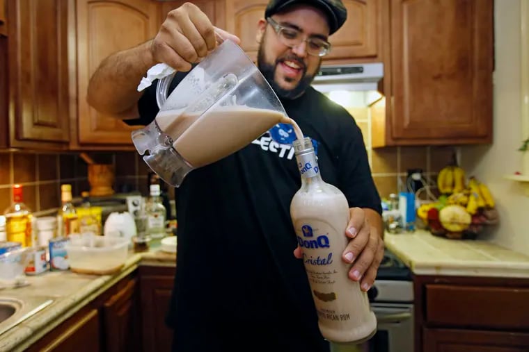 Rivera transfers his coquito from the blender into a bottle. It's common for coquito-makers to whip up huge batches to give as presents.