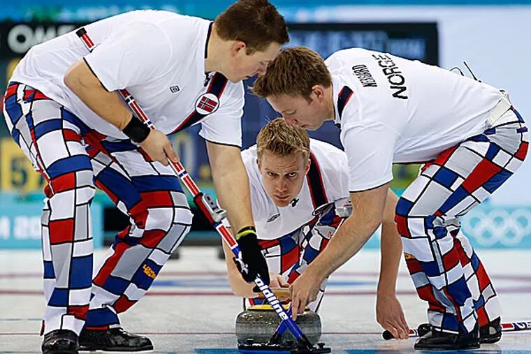 Norway's Haavard Vad Petersson releases the rock to his sweepers Christoffer Svae and Torger Nergaard during men's curling competition. (Robert F. Bukaty/AP)