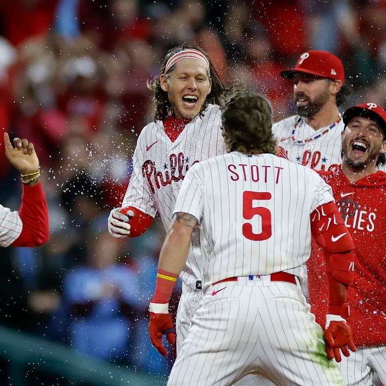 Phillies Alec Bohm celebrates with his teammates after getting the game winning extra innings RBI hit.