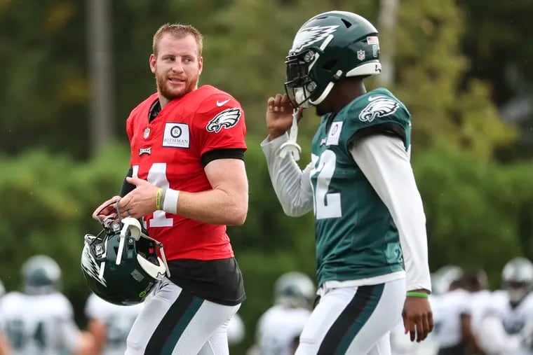 Eagles quarterback Carson Wentz (left) had an up-and-down season in 2019, but threw just three interceptions in his last nine starts.