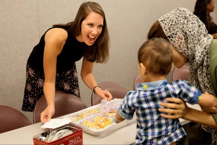 Molly Lester offers fresh cookies to Maryam Sayedzada (right) and her 2-year-old son, Zamir, at the start of an ESL class at the Nationalities Service Center.