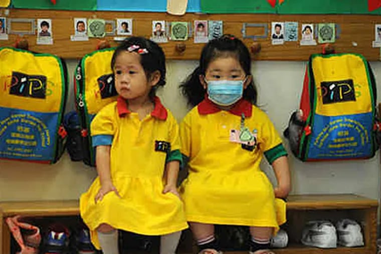 Students at a pre-school facility in Hong Kong, which has ordered all kindergartens and primary schools closed for two weeks after a dozen students tested positive for the swine flu in the territory's first local cluster of cases on Thursday. (AP Photo/Kin Cheung)