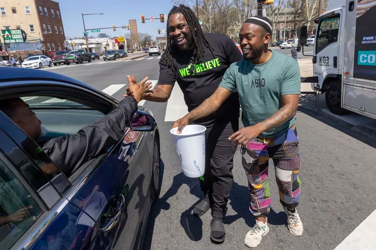 Ryan Harris, founder of the nonprofit group As I Plant This Seed, and Ant Brown, with A Bro Inc., (right) at North Broad Street and West Roosevelt Boulevard on Friday afternoon. Their organizations are joining forces to raise contributions from the public to support their programs.