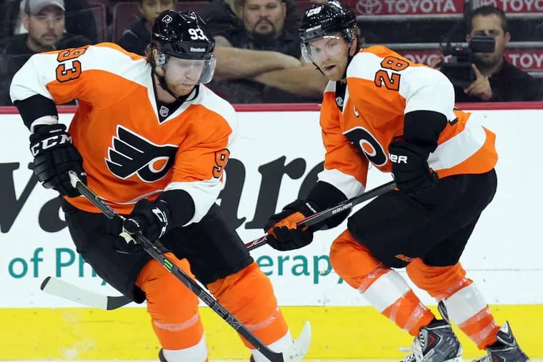 Flyers' Jakub Voracek skates with the puck as Claude Giroux watches against the New York Rangers during a preseason game on Tuesday, September 30, 2014.