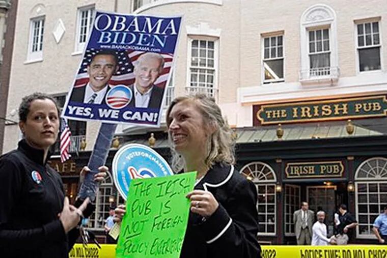 Supporters of Democratic presidential candidate Sen. Barack Obama, D-Ill., Caterina Giordano, left, and Amy Roncace hold signs in front of the Irish Pub in Center City, which Republican vice presidential candidate Alaska Gov. Sarah Palin visited tonight. (AP Photo/Matt Rourke)